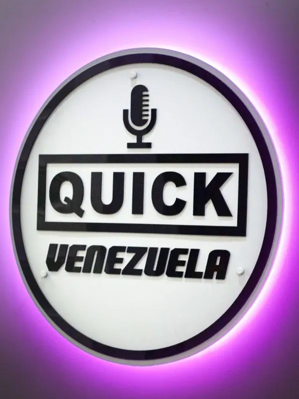 Logo iluminado de Quick Venezuela en una pared